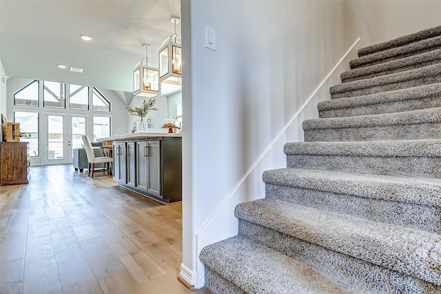 stairway featuring recessed lighting, french doors, and wood finished floors