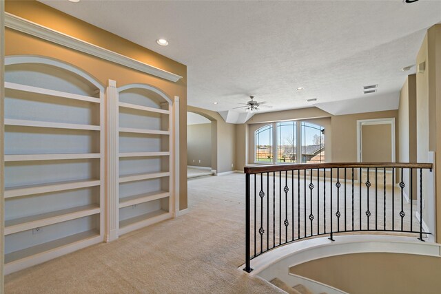 hallway featuring built in features, baseboards, visible vents, carpet floors, and recessed lighting