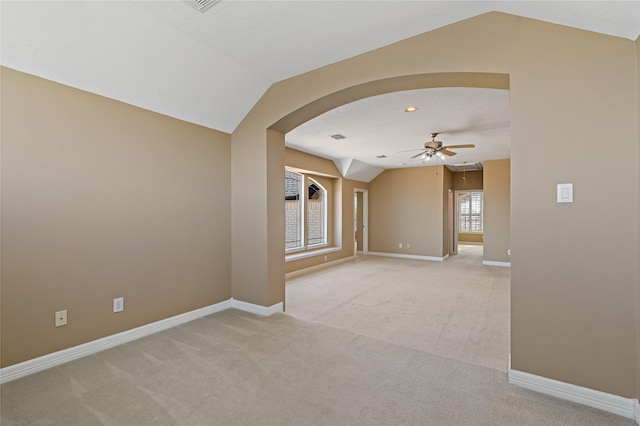 unfurnished room featuring baseboards, light carpet, and vaulted ceiling