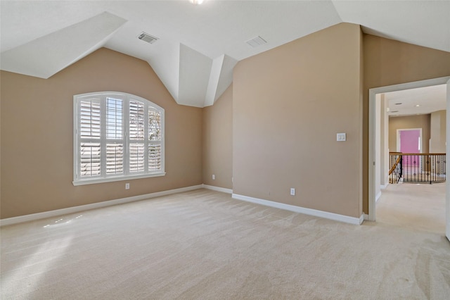 unfurnished room with visible vents, light carpet, baseboards, and vaulted ceiling