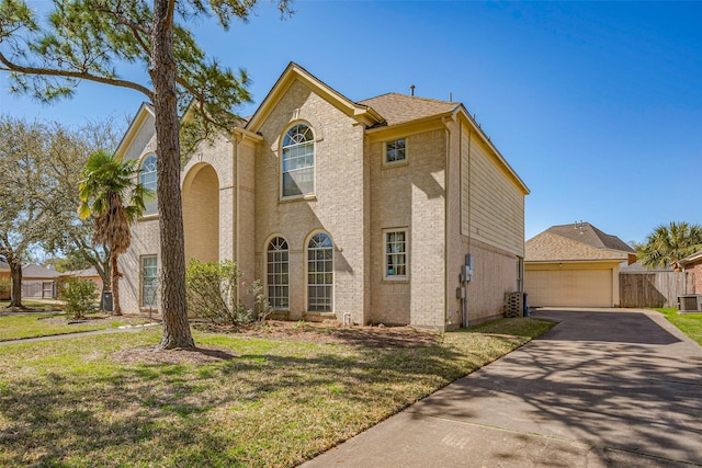 view of front of home with a front yard, cooling unit, fence, and a garage