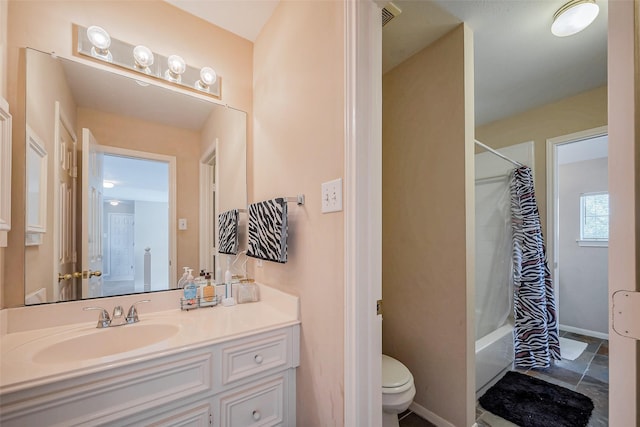 bathroom with toilet, vanity, baseboards, and shower / bath combo