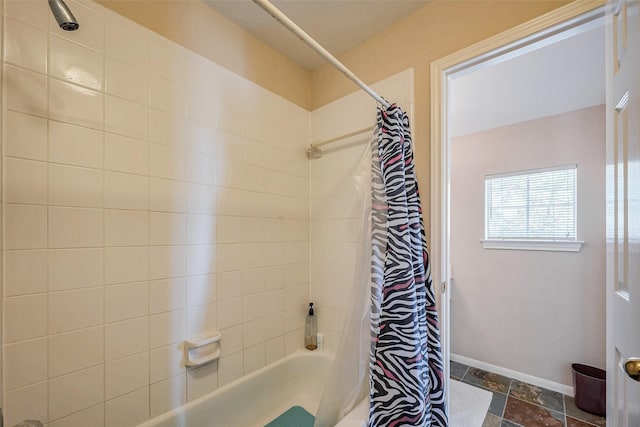 bathroom with baseboards and shower / bath combo with shower curtain