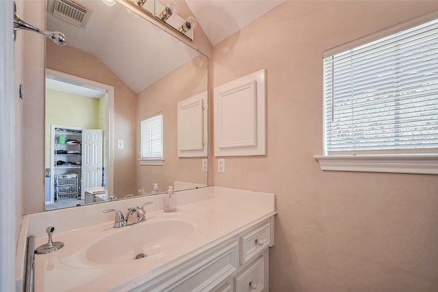 bathroom with visible vents, lofted ceiling, and vanity