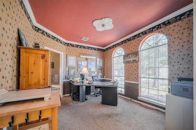 carpeted office space featuring wallpapered walls, crown molding, and visible vents