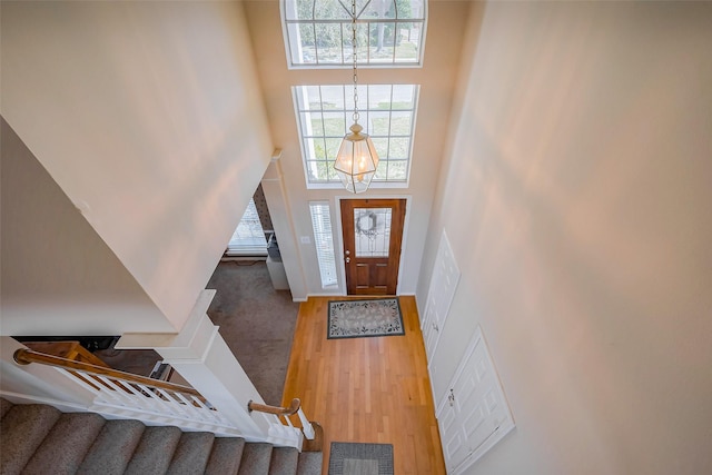 entryway featuring baseboards, wood finished floors, a towering ceiling, and stairs