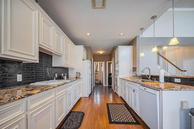 kitchen with visible vents, light wood-type flooring, white appliances, white cabinetry, and a sink