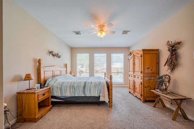 bedroom featuring visible vents, baseboards, light colored carpet, and ceiling fan