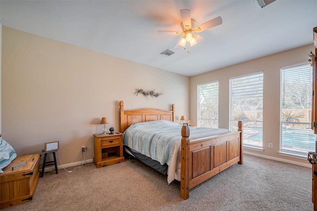 bedroom featuring light carpet, visible vents, and multiple windows