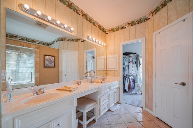 bathroom with tile patterned flooring, visible vents, double vanity, a shower with shower door, and a sink