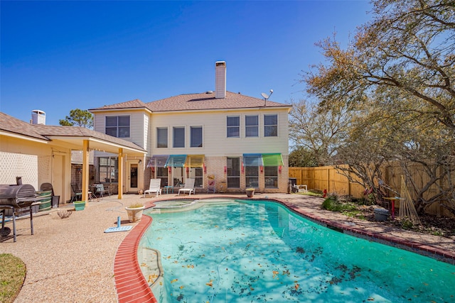 view of swimming pool with a fenced backyard, a pool with connected hot tub, and a patio