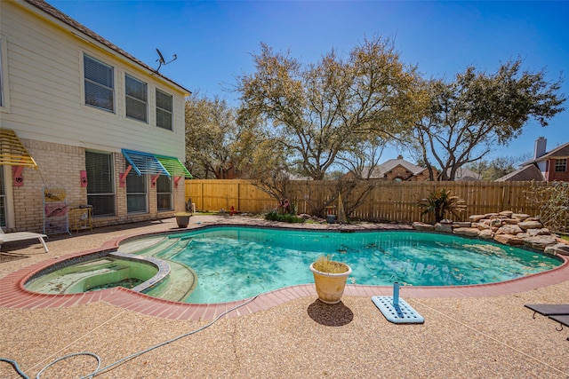 view of swimming pool with a pool with connected hot tub, a fenced backyard, and a patio area