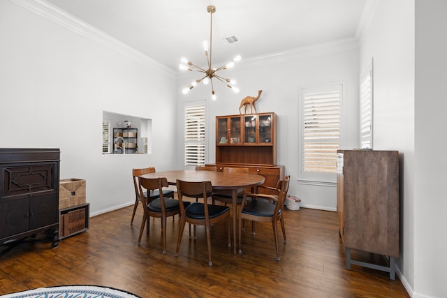 dining area featuring dark wood finished floors, crown molding, baseboards, and an inviting chandelier