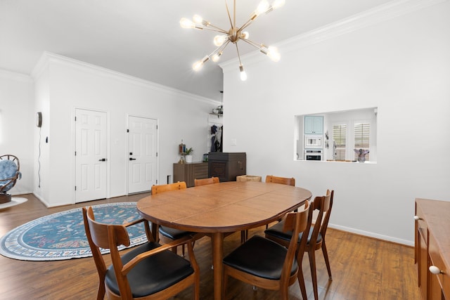 dining area featuring ornamental molding, baseboards, an inviting chandelier, and wood finished floors