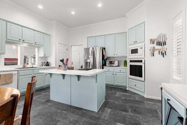 kitchen with white appliances, light countertops, crown molding, and a sink