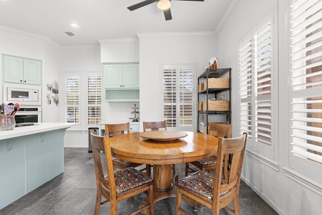 dining room with ceiling fan, baseboards, and ornamental molding