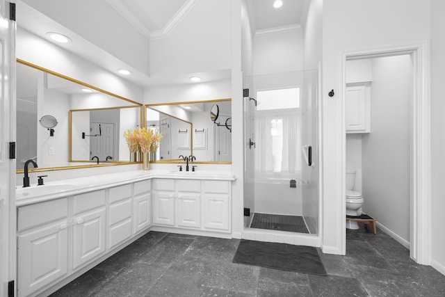 bathroom featuring baseboards, a stall shower, a sink, crown molding, and toilet