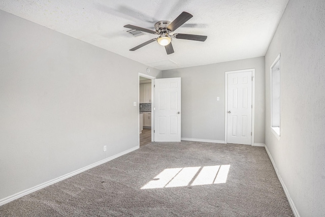 unfurnished bedroom with visible vents, carpet flooring, a textured ceiling, and baseboards