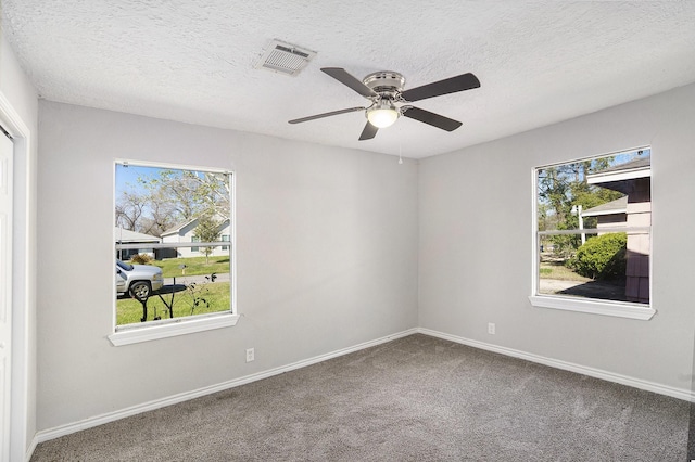 spare room featuring a ceiling fan, baseboards, visible vents, a textured ceiling, and carpet flooring