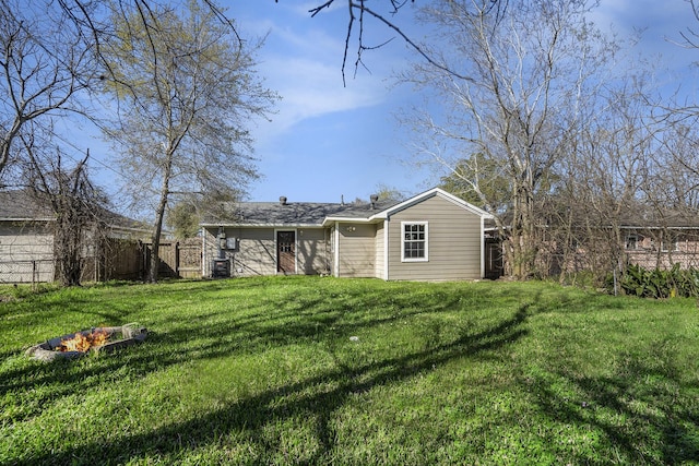 rear view of property with a yard and fence