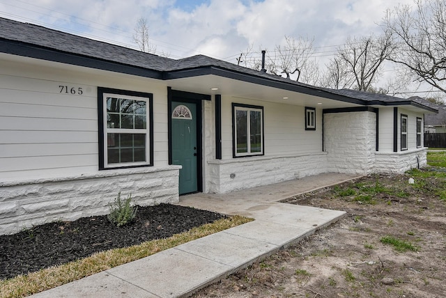 property entrance featuring stone siding