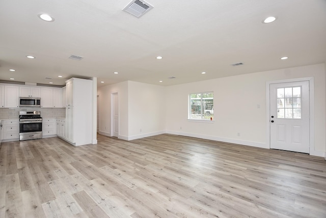 unfurnished living room with visible vents, recessed lighting, and light wood-type flooring