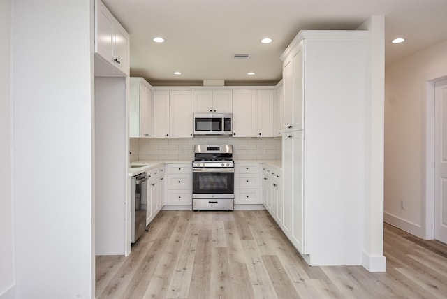 kitchen with light wood-style flooring, recessed lighting, light countertops, appliances with stainless steel finishes, and backsplash