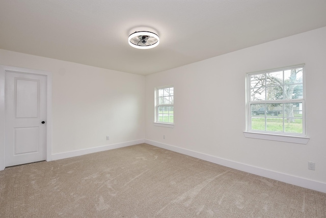 spare room with light colored carpet and baseboards