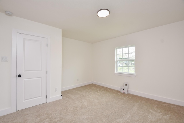 empty room with light colored carpet and baseboards