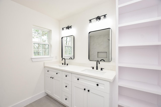 bathroom with a sink, baseboards, double vanity, and tile patterned floors