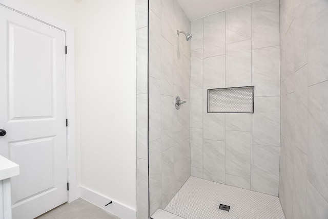 bathroom featuring baseboards and tiled shower