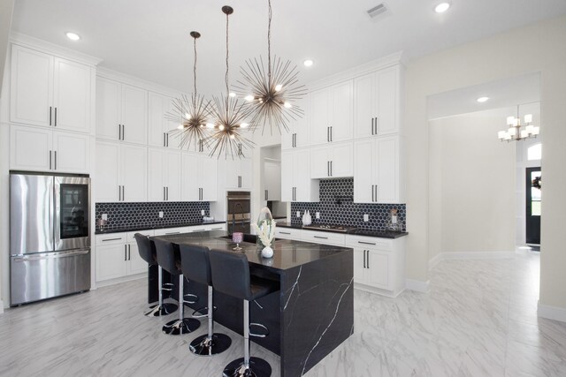 kitchen with dark countertops, visible vents, a chandelier, marble finish floor, and stainless steel appliances