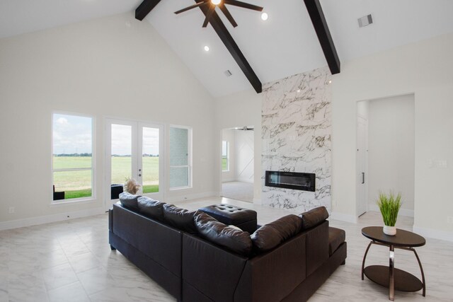 living area with visible vents, plenty of natural light, a fireplace, and high vaulted ceiling