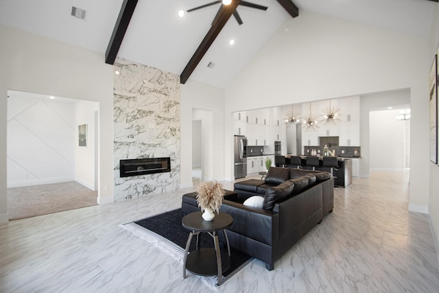 living area with beam ceiling, visible vents, marble finish floor, and a premium fireplace