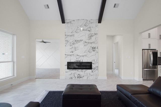 living room with lofted ceiling with beams, visible vents, baseboards, and a high end fireplace