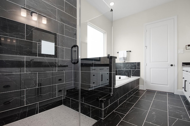 bathroom featuring a garden tub, marble finish floor, a stall shower, and vanity