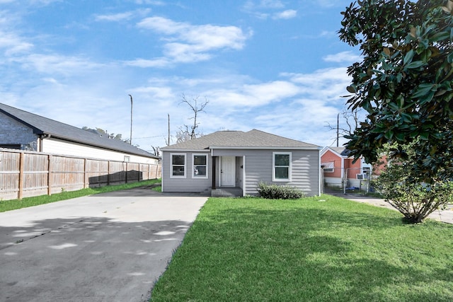 bungalow featuring a front lawn and fence