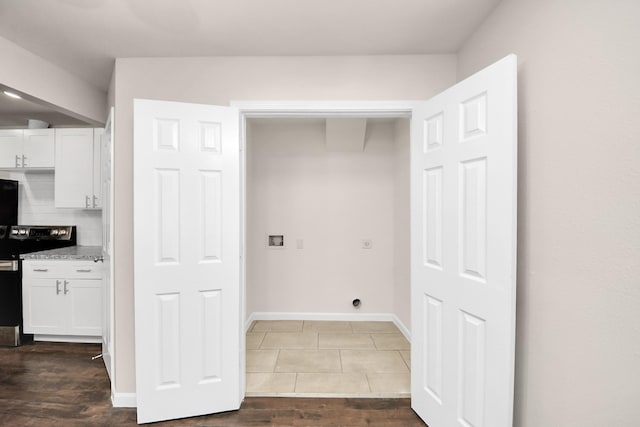 washroom with baseboards, hookup for an electric dryer, dark wood-style floors, and laundry area