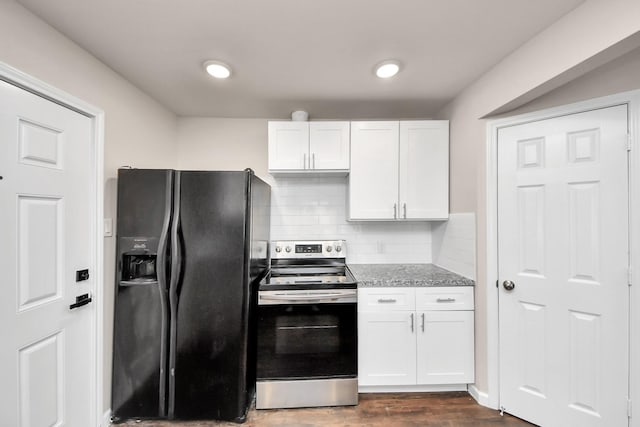 kitchen with dark wood-type flooring, black fridge, tasteful backsplash, white cabinetry, and stainless steel electric range