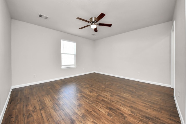 spare room featuring dark wood-type flooring, baseboards, and ceiling fan