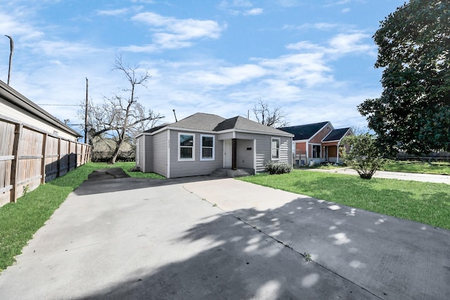 view of front of home featuring concrete driveway, a front yard, and fence