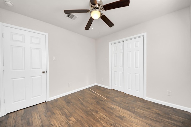 unfurnished bedroom with visible vents, baseboards, a closet, and dark wood-style flooring