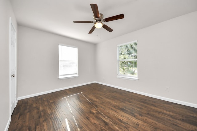 unfurnished room with a ceiling fan, dark wood-type flooring, and baseboards