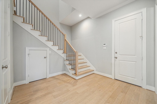 foyer entrance featuring stairway, recessed lighting, wood finished floors, and baseboards