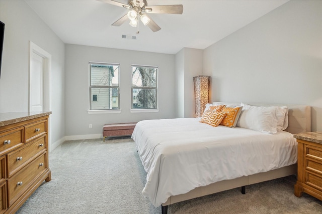 bedroom featuring a ceiling fan, light colored carpet, visible vents, and baseboards