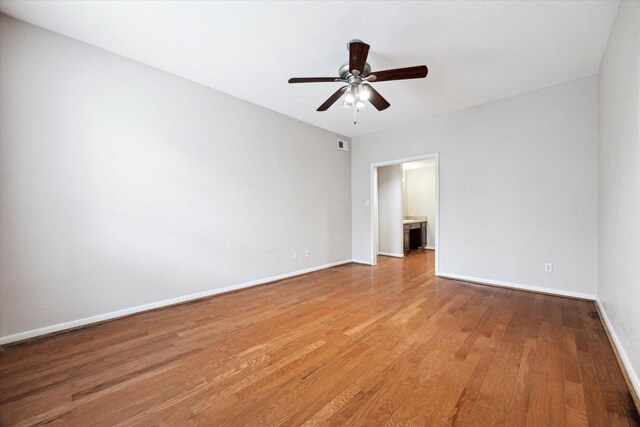 unfurnished room featuring ceiling fan, visible vents, baseboards, and wood finished floors