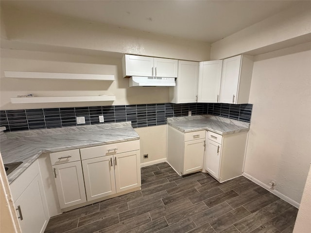 kitchen with under cabinet range hood, backsplash, white cabinets, and wood finish floors