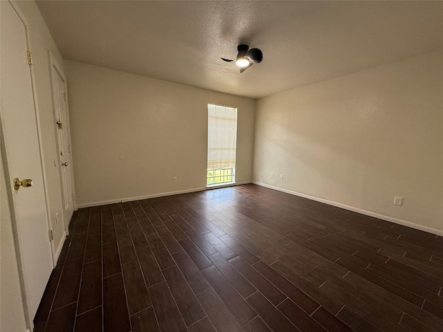 empty room featuring baseboards, a textured ceiling, dark wood finished floors, and a ceiling fan