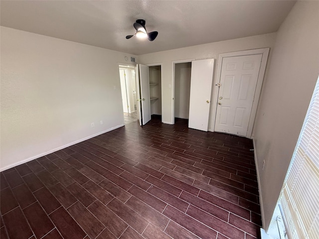 unfurnished bedroom featuring a ceiling fan, baseboards, and dark wood-style flooring