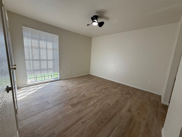 empty room with baseboards and wood finished floors